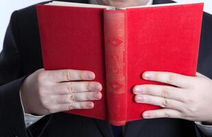 man holding an open red book photo
