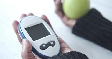A person holding a digital thermometer and an apple video