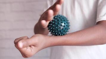 A person holding a ball with a green spiky ball video