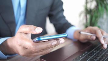 A man in a suit holding a cell phone video
