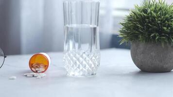 A glass of water and pills on a table video