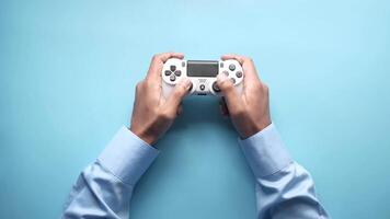 Hands holding a game controller on a blue background video