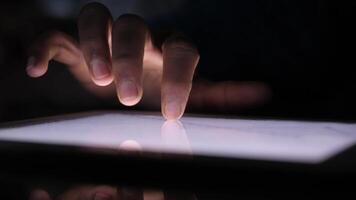 A person's hand is touching a tablet screen video