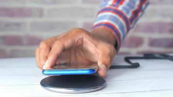 A person is holding a cell phone on a wireless charger video