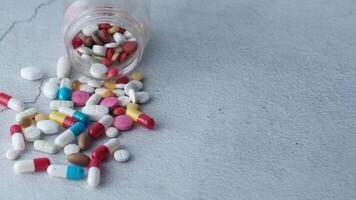 A bottle of pills spilling out onto a table video