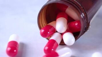 Pills spilling out of a bottle on a table video