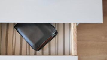 A wallet is sitting in a drawer on a desk video