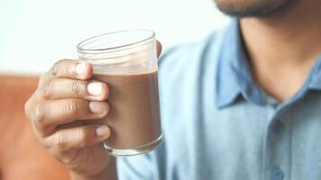 man hand holding glass of chocolate milk at early morning video