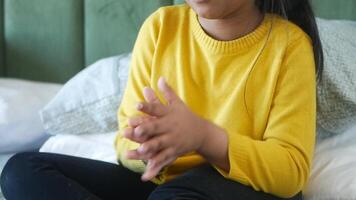 child clapping hands and smiling, sitting on sofa . video