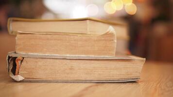 A stack of books neatly arranged on a table with a soft bokeh background, creating a cozy feel video