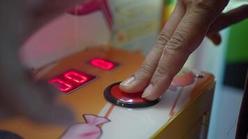 A CloseUp of a Hand Delicately Pressing a Colorful Button on a CandyThemed Arcade Machine video