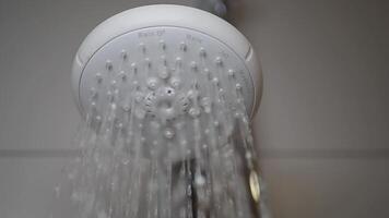 A detailed closeup view of a showerhead with water gracefully flowing down from it video