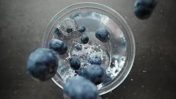 Blueberries fall into the plate with water video
