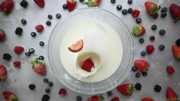 A bowl of milk adorned with strawberries and blueberries on a table video