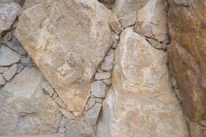 The walls are made of large stones and cobblestones. Stone background. photo