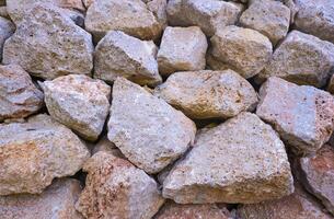 Texture of a stone wall. Old castle stone wall texture background. Brown, sienna large stones. Part of a stone wall, for background or texture photo