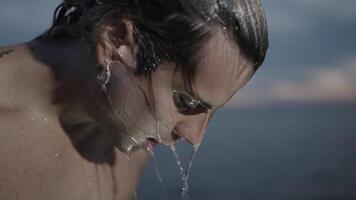 A Young Man Joyfully Playing in Water Creating a Refreshing Splash video