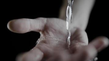 Close-up of water flowing over open hand in four frames sequence video