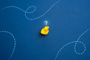 Yellow duck thinks where to swim. Concept of navigation and making plans for the future. Find your purpose in life and when choosing a profession. Search for new ideas and goals. photo