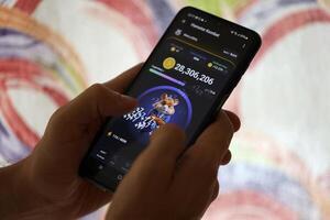 KYIV, UKRAINE - JUNE 26, 2024 Hamster Kombat telegram mini-game in tap 2 earn genre. Tap game on smartphone in hand photo