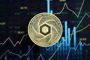 KYIV, UKRAINE - AUGUST 17, 2024 Chainlink LINK coin on abstract fictional candlesticks in trading chart in blue color photo