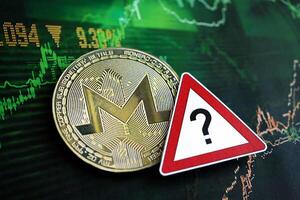 KYIV, UKRAINE - AUGUST 17, 2024 Monero XMR coin and red paper question sign on chart background photo