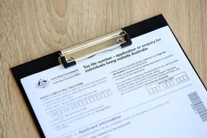 KYIV, UKRAINE - JULY 10, 2024 Australian Tax File Number Application or enquiry for individuals living outside Australia blank form lies on table of Australian Government taxation office photo
