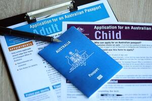 KYIV, UKRAINE - JULY 10, 2024 Application for an Australian passport for adult and child blank forms on table. Department of foreign affairs and Trade photo