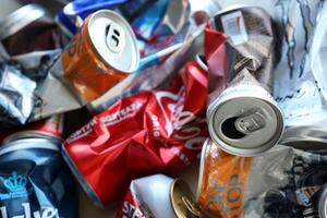 KYIV, UKRAINE - APRIL 20, 2024 Background of various crashed beer cans. Recycle aluminum metal crushed tin can waste photo