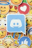 KYIV, UKRAINE - APRIL 20, 2024 Discord logo and large set of stickers with Emoji yellow faces. Emoji is a pictogram or smiley embedded in text and used in electronic messages photo