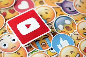 KYIV, UKRAINE - APRIL 20, 2024 YouTube logo and large set of stickers with Emoji yellow faces. Emoji is a pictogram or smiley embedded in text and used in electronic messages photo