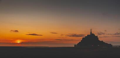Panoramic view of the famous abbey of Le Mont Saint-Michel at sunset, Normandy, France photo