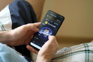 KYIV, UKRAINE - APRIL 20, 2024 Hamster Kombat telegram bot on smartphone screen. Hamster Kombat is a viral Telegram crypto game for earn HMSTR tokens by managing virtual crypto exchange photo