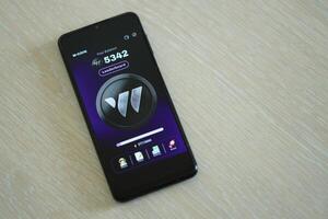 KYIV, UKRAINE - APRIL 20, 2024 W-coin telegram bot on smartphone screen. W-coin is a viral Telegram based crypto game for earn tokens by managing virtual crypto exchange photo