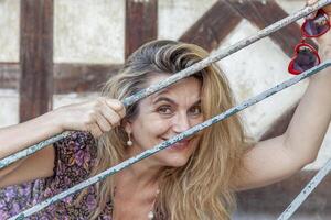portrait of beautiful middle aged woman in front of a typical french half-timbered house photo