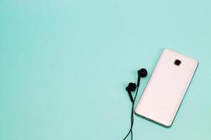 phone and headphones on a light background. background with space for text photo