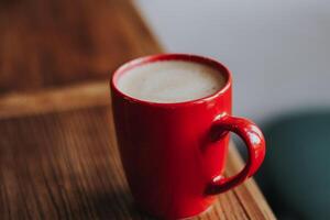 red cup with mokachino coffee in a cafe on a dark background photo