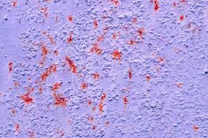 Closeup view of old weathered lilac texture with red patches. Paint and rust texture photo