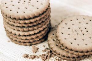 Crispy chocolate cinnamon with holes on a wooden board. Round biscuits with filling. space for text photo