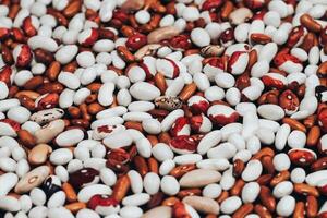 View from above. multi-colored beans scattered on a black background. background with space for text. Texture photo