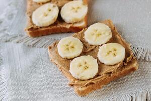 sandwich with peanut butter and bananas. Healthy and tasty breakfast or snack. photo