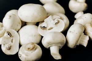 champignon mushrooms on a black background. space for text photo