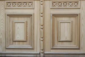 fragment of wooden pattern for the decoration of doors and walls. wood texture with pattern. part of the door photo