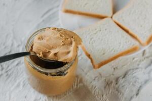 thick peanut butter in a jar close-up. Healthy eating photo