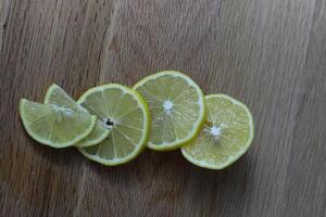 lemon slices neatly cut and lie on a wooden background. space for text photo