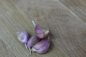 cloves of garlic on a wooden background close-up. Purple garlic photo