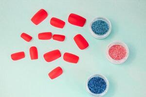 manicure flat on a turquoise background. glitters for manicure or makeup design, false nails photo
