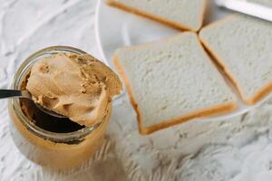 thick peanut butter in a jar close-up. Healthy eating photo