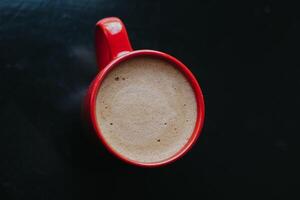 red cup with mokachino coffee in a cafe on a dark background photo
