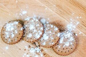 Crispy chocolate cinnamon with holes on a wooden board. Round biscuits with filling. space for text photo